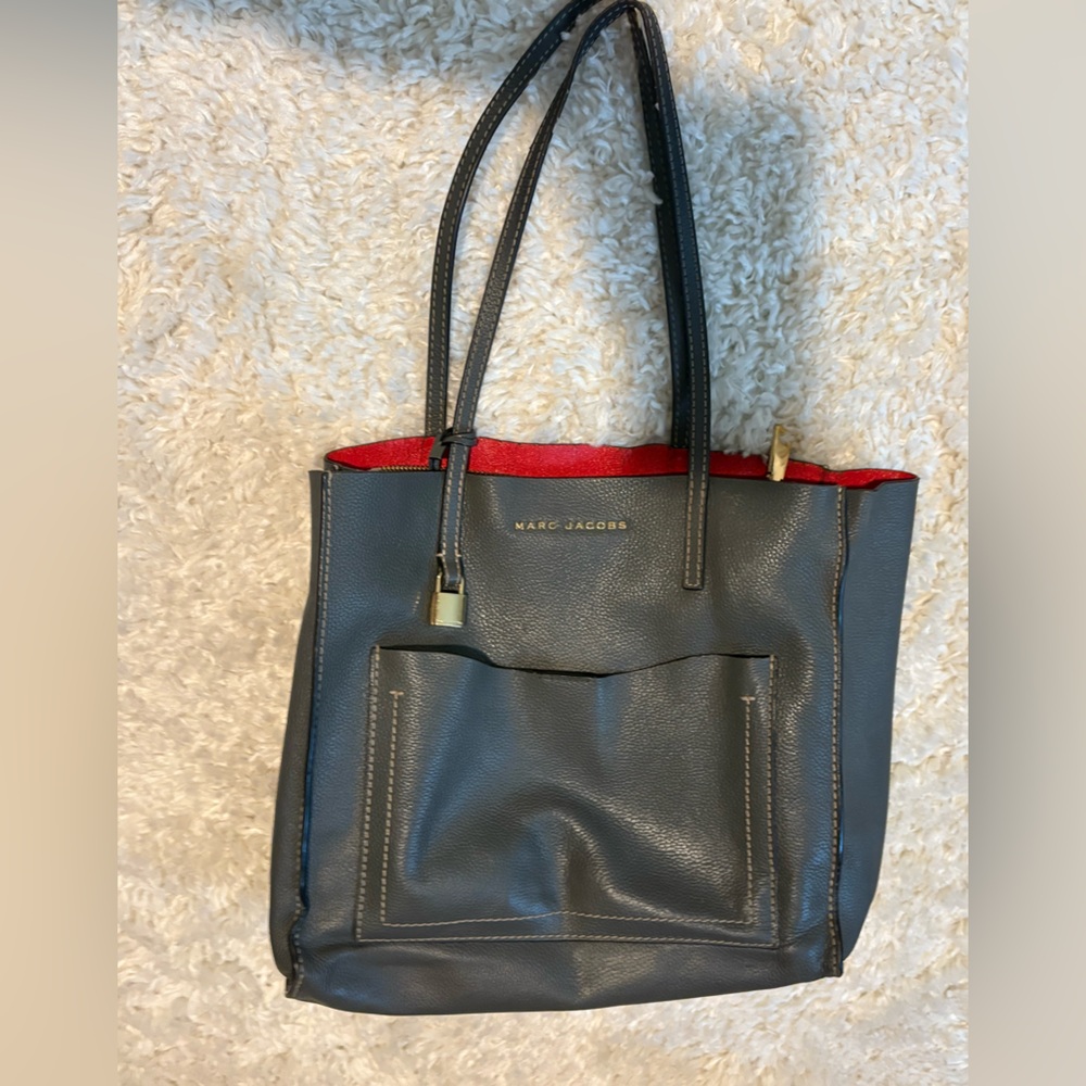 Like new gray leather Marc Jacobs purse with red leather inside. Magnetic pocket